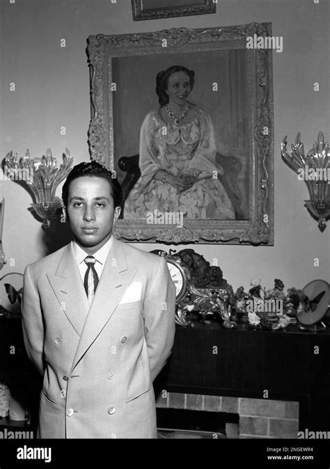 King Faisal Ii Of Iraq Poses Before A Portrait Of His Mother In The