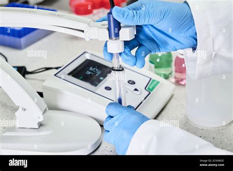 Woman In A Rubber Gloves Holding A Glass Electrode For Measuring Of PH