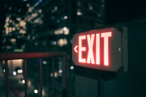 Illuminated Exit Sign against City at Night · Free Stock Photo