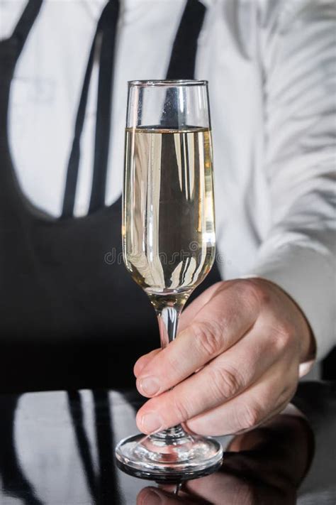 A Professional Bartender Serves Chilled Champagne Sparkling With Gases