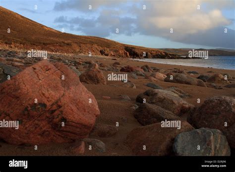 A Rocky And Sandy Beach With Red Rocks And Red Sand At Muckle Roe