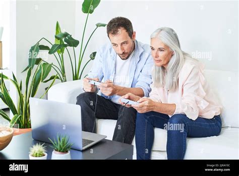 Mature Woman With Son Playing Video Game At Home Stock Photo Alamy
