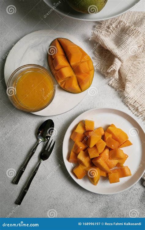 Isolated Glass Of Mango Juice With Fresh Mango Fruit Slices On Rustic