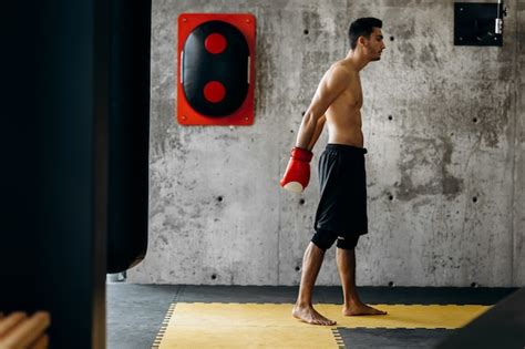 Premium Photo Brutal Dark Haired Guy With A Naked Torso And The Red Boxing Gloves Stands
