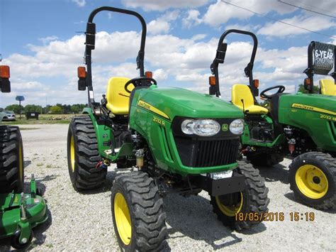 Three Green Tractors Are Parked On The Gravel