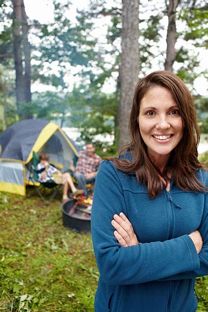 Camping Couple Smiling Posing By Tent Campfire In Campground Vertical