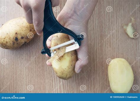 Hands Peeling Potato With Black Peeler Stock Photo Image Of Little