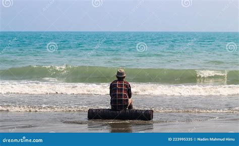 Vista Trasera De Un Joven Sentado En La Playa De Arena Durante La