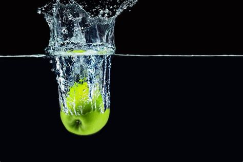 Manzana Verde Cayendo En El Agua Con Un Toque Sobre Fondo Oscuro Cerrar