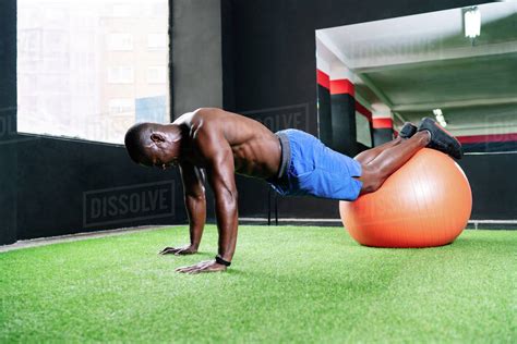 Side View Of Muscular African American Male Athlete With Naked Torso Doing Abdominal Crunches On