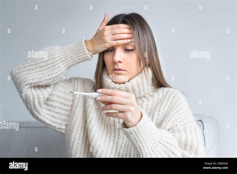 Mujer enferma con fiebre que mide la temperatura con un médico