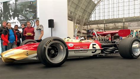 Some People Are Standing Next To A Racing Car