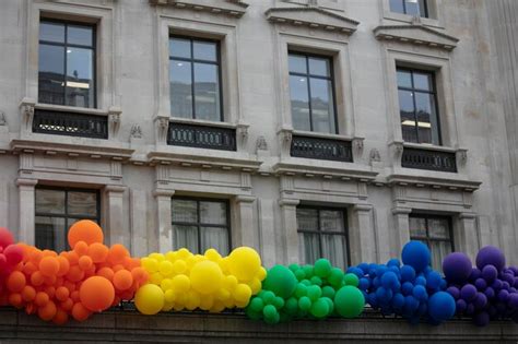 Bandeira de arco íris do orgulho gay feita de balões pendurada em um prédio Foto Premium
