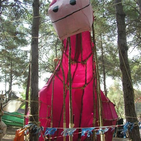 A Large Pink Inflatable Animal Sitting Among The Trees