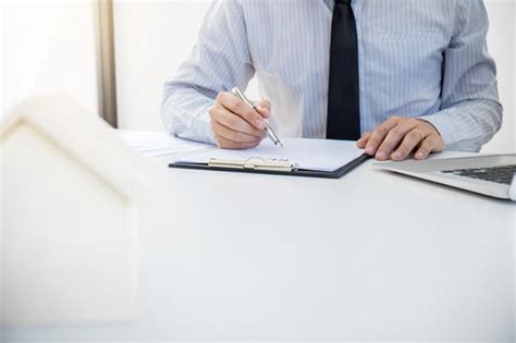 Premium Photo Midsection Of Businessman Writing In Book At Office