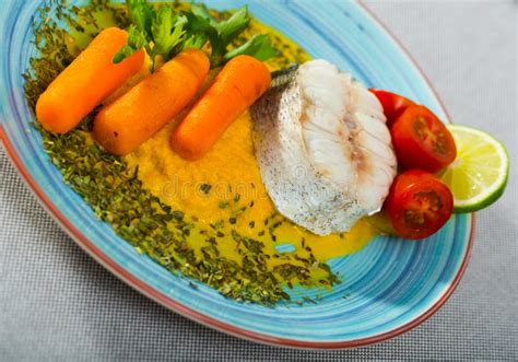 Steamed Hake Served With Vegetable Pate Carrots Lemon Greens And