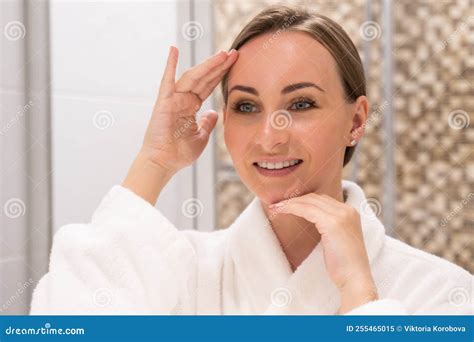 Young Woman Touches And Checks Facial Skin Looking In Mirror Stock Image Image Of Hotel