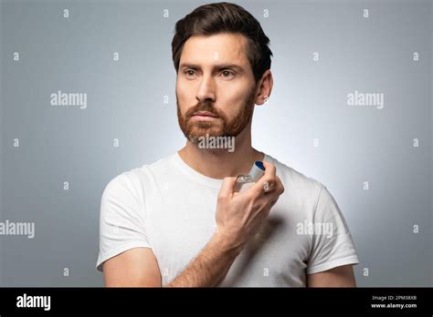 Handsome Caucasian Middle Aged Man Spraying Perfume On Himself Posing