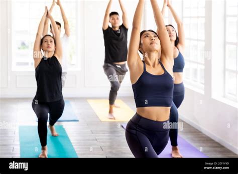 Group Of Young Sporty Attractive Asian People Practicing Yoga Lesson On