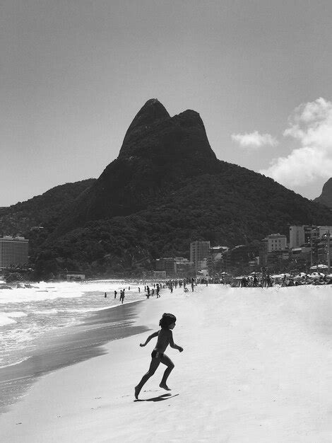 Um menino está montando uma prancha de surf em uma praia uma