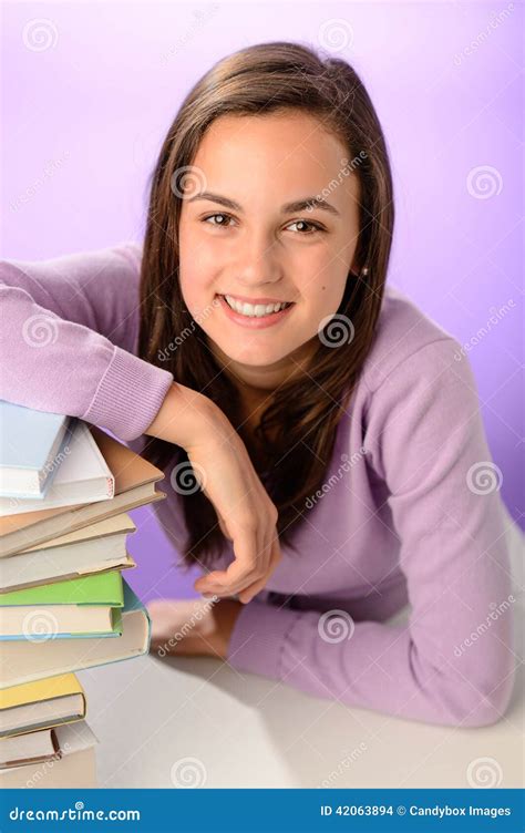 Menina De Sorriso Do Estudante A Pilha Dos Livros Foto De Stock