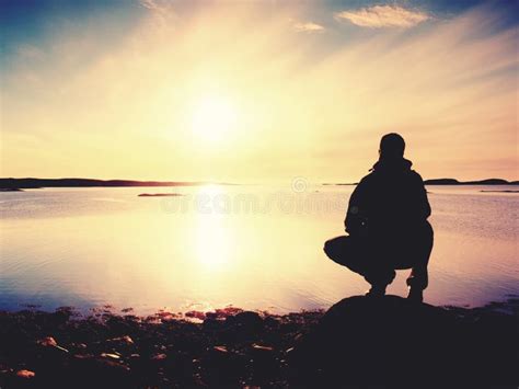 Young Man Sitting On A Rock Watching A Gorgeous Sunset On The Sea. Hiker Alone Enjoy Evening ...