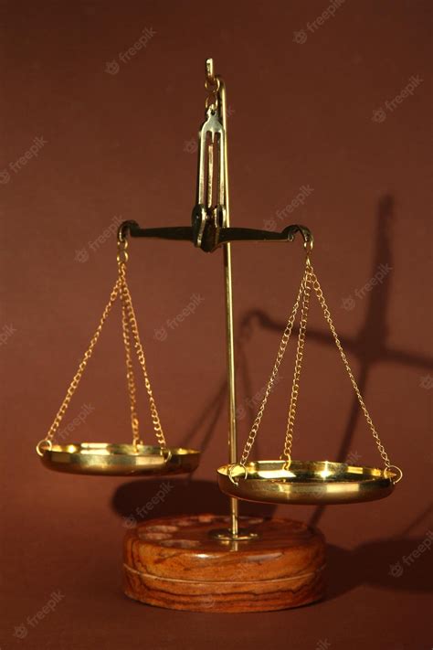 Premium Photo | Gold scales of justice on brown background