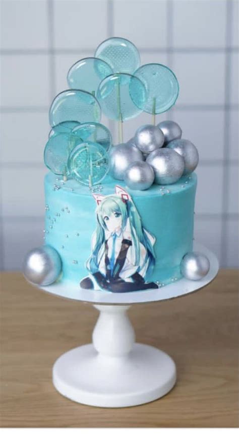 There Is A Blue Cake With Silver Decorations On The Top And An Anime