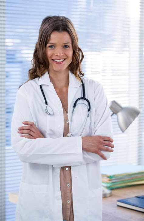 Portrait Of A Smiling Female Doctor Standing With Arms Crossed Stock