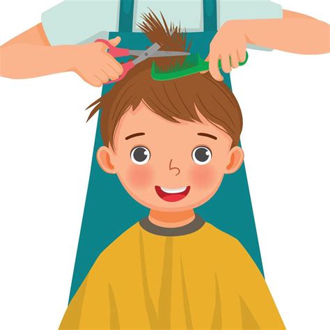 Cute little boy getting hair cut by hair dresser in the hair salon ...