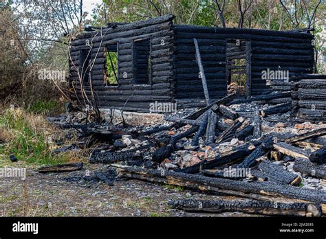 The Remains Of A Burnt Log House On The Background Of Nature Stock