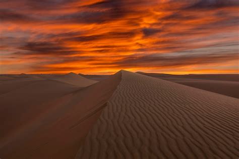 Puesta de sol sobre las dunas de arena en el desierto paisaje árido del