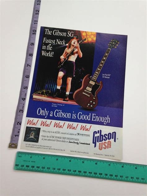 An Advertisement For Gibson Guitars Is Displayed Next To A Ruler