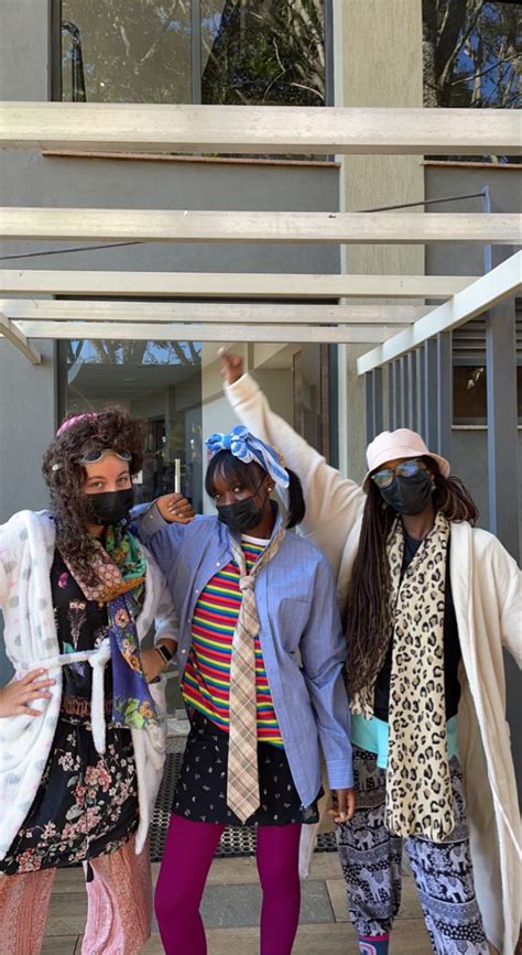 Three People Wearing Face Masks And Standing In Front Of A Building