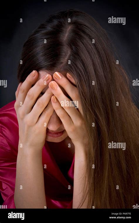 A Depressed Woman Holds Her Head In Her Hands Stock Photo Alamy