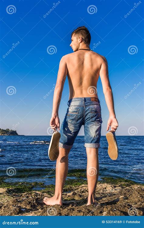 Jeune Homme Nu Sexy Beau Attirant Sur La Roche Près Du Wa De Mer Photo