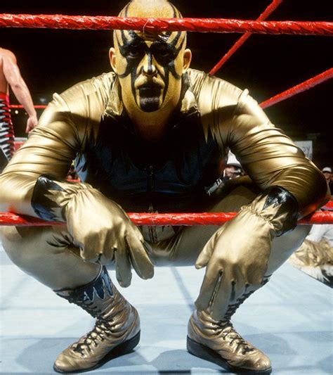 A Wrestler Sitting In The Ring With His Hands On His Knees