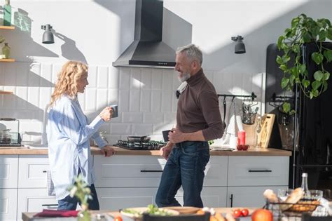 Premium Photo Mature Couple In The Kitchen Looking Happy While Cooking Breakfast