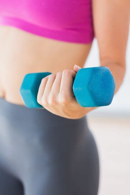 Premium Photo Mid Section Of A Woman Lifting Dumbbell Weight