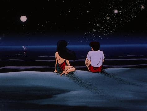 Two People Sitting In The Snow Looking At The Stars