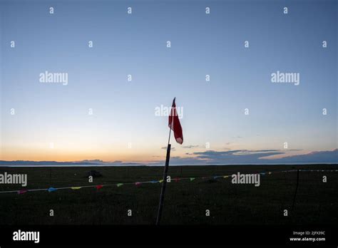 A border on the beach separated by different colored flags a large red ...