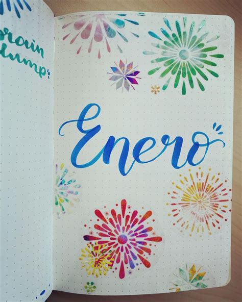 An Open Notebook With The Word Enero Written In Blue Ink And Colorful