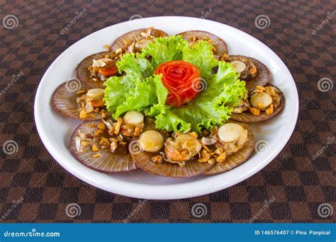 Conchas De Peregrino Fritas Con El Ajo Adornado Con Las Zanahorias En