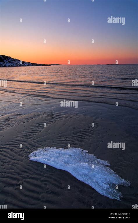 ice block lying  beach  sunset vallda sando halland sweden stock