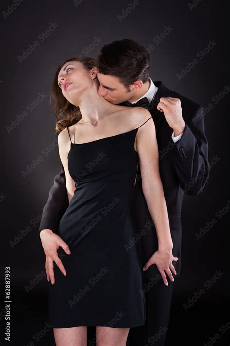 Man Kissing Woman On Neck While Removing Dress Strap Stock Photo | Adobe Stock