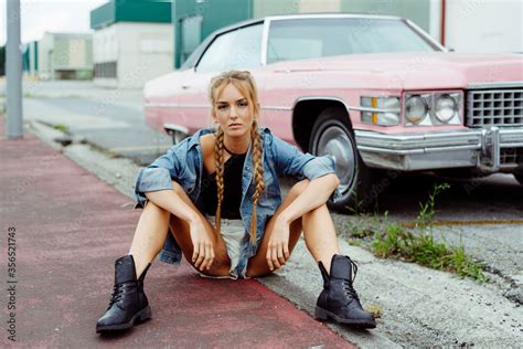 Attractive Blonde Girl Sitting On The Sidewalk Near To A Classic Pink Car Stock Photo Adobe Stock