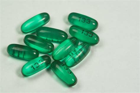 Green Oval Pills In The Lid On A White Background Stock Photo Image