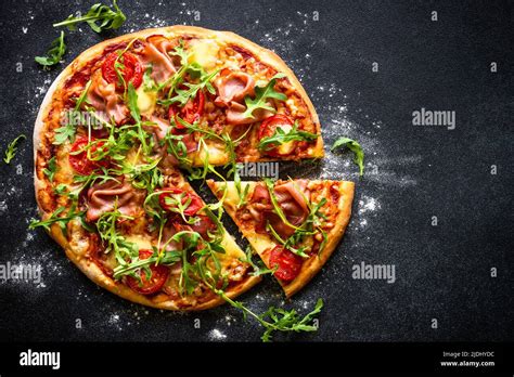 Traditional Italian Pizza With Ham Cheese Tomatoes And Arugula On