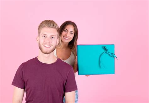 Mujer Joven Sonriente Que Sostiene La Caja De Regalo Que Se Coloca