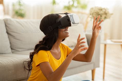 Side View Of African American Woman Playing Realistic Video Game In Virtual Reality Glasses At